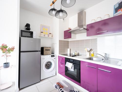 une cuisine avec des placards violets et un lave-linge/sèche-linge dans l'établissement Le Charme de Tremblay entre Stade de France et CDG, à Tremblay-en-France