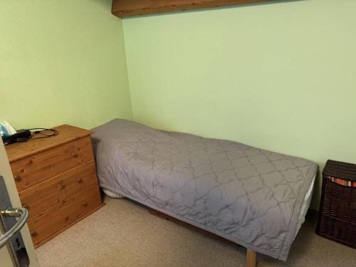 ein kleines Schlafzimmer mit einem Bett und einer Holzkommode in der Unterkunft HOLIDAYLAND VILLA 217 T2 6 couchages NARBONNE PLAGE in Narbonne-Plage