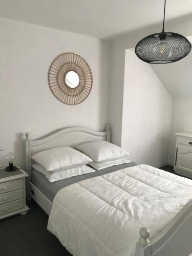 une chambre blanche avec un lit et un miroir dans l'établissement Duplex, à La Celle-sous-Gouzon