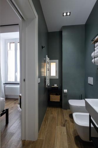 a bathroom with a white toilet and a green wall at Style & Stone Guest House in Rome