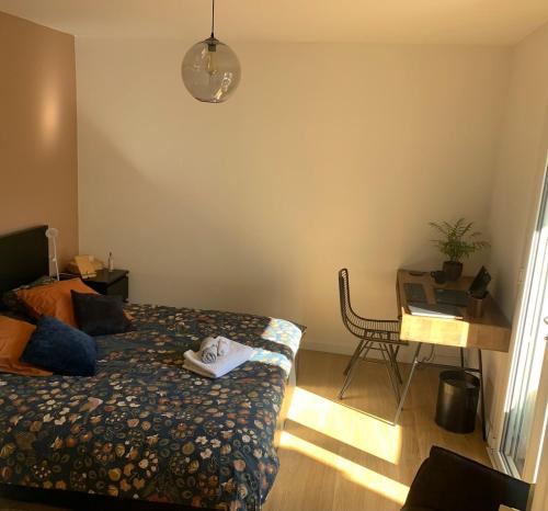 une chambre avec un lit et une table avec un ordinateur portable dans l'établissement Cozy Accommodation - Montpellier, à Montpellier