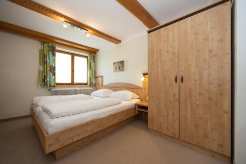 a bedroom with a large bed and a wooden cabinet at Pension Appartments Christoph in Westendorf