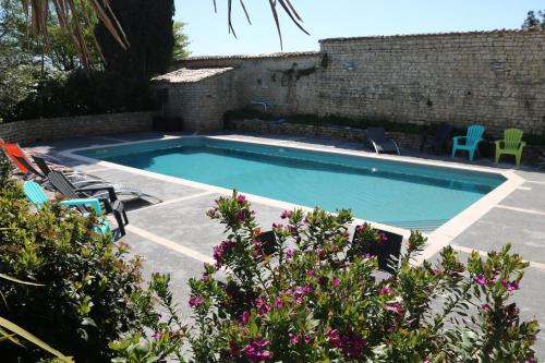 - une piscine dans une cour agrémentée de chaises et de fleurs dans l'établissement Villa del Re 2 face à la piscine, à La Flotte