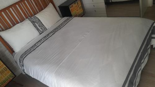 a large white bed with a wooden head board at Loft Moderno - High Security And Garage Shoppings in Sao Paulo
