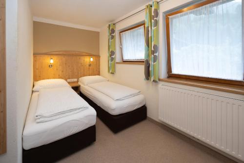two beds in a small room with a window at Pension Appartments Christoph in Westendorf