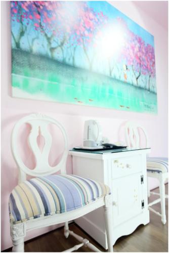a room with two chairs and a table and a painting at Errantry Lodge & Studio in Hualien City