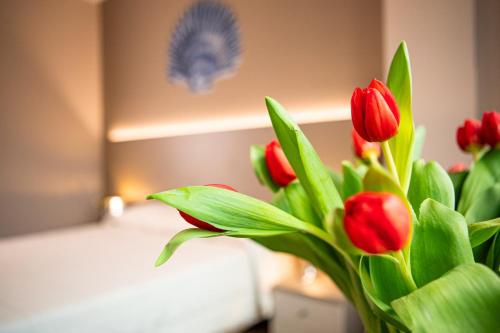 a bouquet of red tulips in a room at Hotel Italia in Lerici