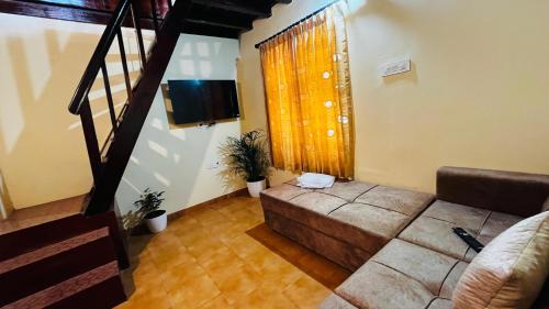 a living room with a couch and a television at Pragathi Homestay in Mananthavady