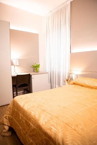 a hotel room with a bed and a desk at Hotel Italia in Lerici