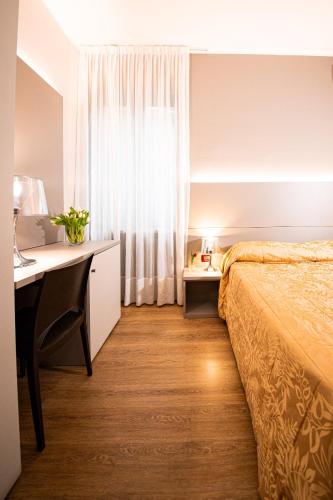 a bedroom with a bed and a desk and a bed at Hotel Italia in Lerici