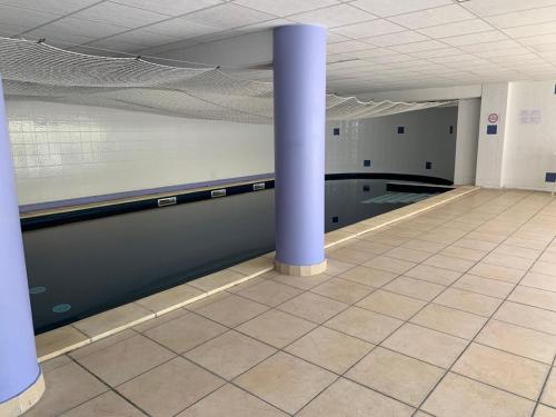 une chambre vide avec colonne et carrelage dans l'établissement Appartement dans résidence avec piscine et parking, à Uzès