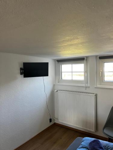 ヘルフォルトにあるFerienwohnung Meierhofの壁に薄型テレビが取り付けられた寝室