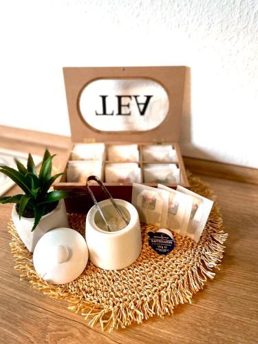 a table with a box of soy candles and a plant at WLAN,Smart TV,4 Betten, Zentral in Emden
