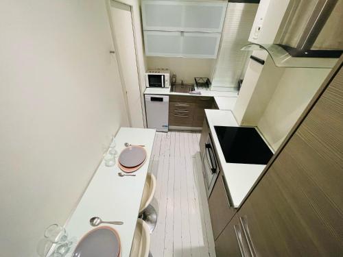 une petite cuisine avec des comptoirs blancs et un évier dans l'établissement Appartement Éclatant, Place de la Pucelle - 378, à Rouen