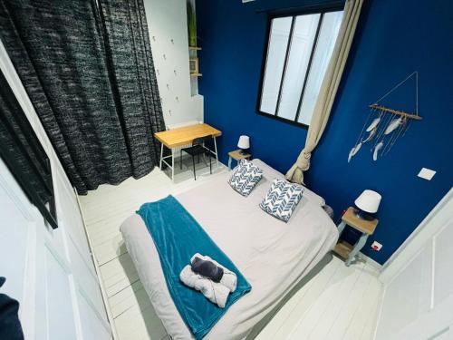 - une chambre avec des murs bleus et un lit avec des serviettes dans l'établissement Appartement Éclatant, Place de la Pucelle - 378, à Rouen