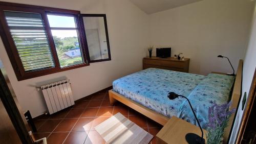 a bedroom with a bed and a window and a table at Villa CARLOTTA in Brucoli