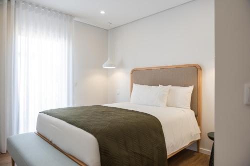 a bedroom with a large bed and a window at Azores Homes Resort & Spa in Ponta Delgada