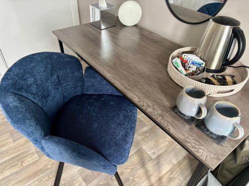 ein blauer Stuhl neben einem Holztisch in der Unterkunft Fife Arms Guest House in Keith