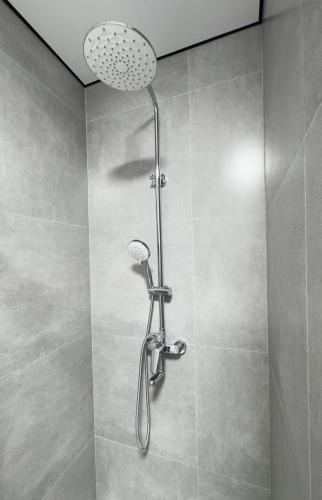 a shower with a shower head in a bathroom at Студия красивая in Almaty