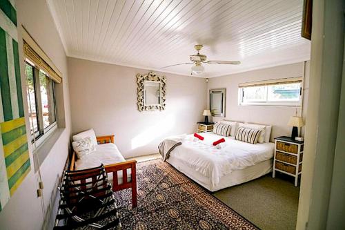 a bedroom with a bed and a chair in it at 90 On Wellington Cottage in Port Elizabeth