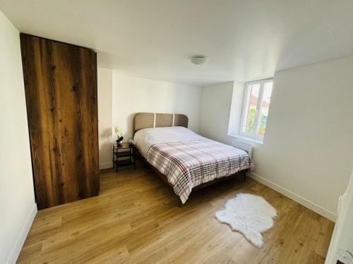 une petite chambre avec un lit et une fenêtre dans l'établissement Appartement Basilique Saint Denys, à Argenteuil