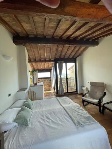 a bedroom with a large bed and a chair at Fairytale apartment in 12th century castle - Umbria in Monte lʼAgello