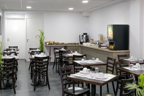 a restaurant with wooden tables and chairs and a counter at Hotel Foch Nancy Gare in Nancy
