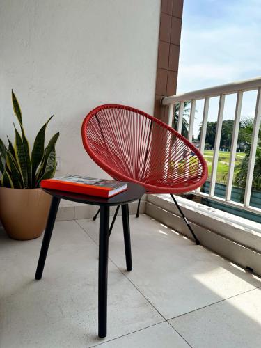 a red chair sitting in front of a window at Résidence Victorine in Douala