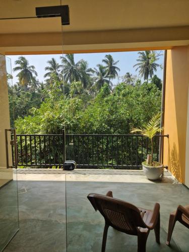 a room with a balcony with a view of the trees at Nature Paradise Guesthouse in Waikkal