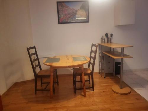 a wooden table and chairs in a room at Appolon in Colmar