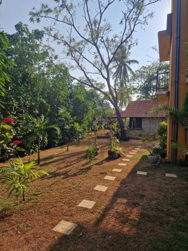 a garden with a walkway in front of a building at Nature Paradise Guesthouse in Waikkal