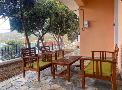 - un ensemble de chaises et de tables en bois sur une terrasse dans l'établissement Πέτρινη αυλή, Αρμενιστης Ικαρια, à Armenistis