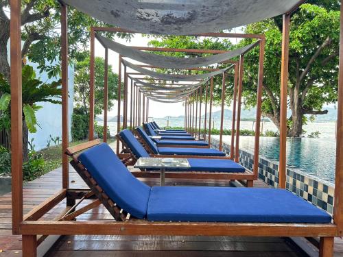 a row of blue lounge chairs sitting on a deck at Casa De Mar - Koh Samui in Chaweng