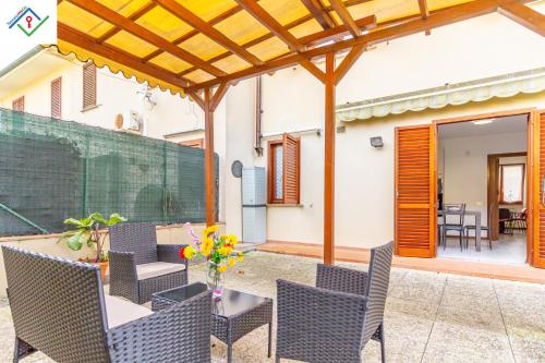 a patio with chairs and a table with flowers on it at La Casa Di Nico by TuscanyWeGo in Capannori