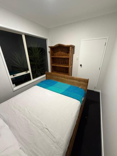 a small bedroom with a bed and a window at Your Central Paradise in Palmerston North