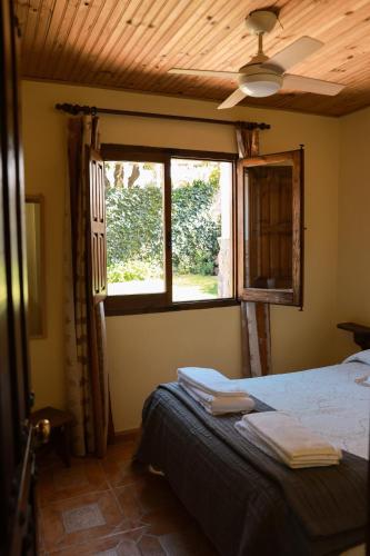 a bedroom with a bed and a window at El arroyo del valle in Navaconcejo