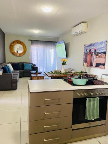 a kitchen with a stove and a living room at NJ MERENSKY 1 Windhoek in Windhoek