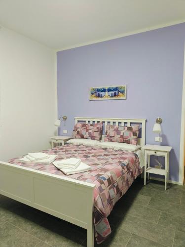 a bedroom with a large bed with two tables at Villa Petra - Πέτρα in Alpignano