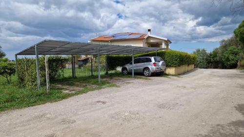 a car parked under a canopy in front of a house at Grazia's Apartment in Sassari