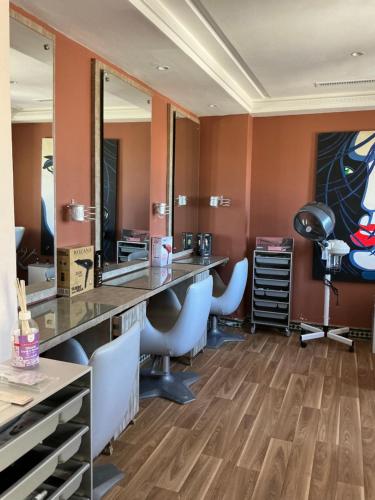 a salon with chairs and a vanity with mirrors at Palm Palace Bouznika in Bouznika