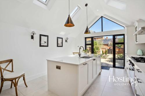 a kitchen with white cabinets and a large window at Number Ten - Beautiful 3-Bedroom Luxury Home in Henley on Thames