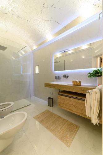 a bathroom with a sink and a toilet and a mirror at Paradise Luxury Apartment Salerno Center in Salerno