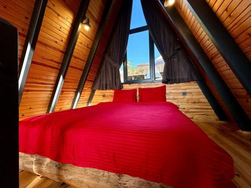 - un lit rouge dans une chambre avec fenêtre dans l'établissement Sapanca life garden bungalov, à Sapanca