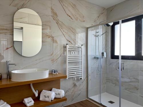 a bathroom with a shower and a sink and a mirror at Azores Homes Resort & Spa in Ponta Delgada