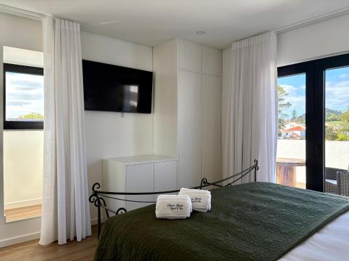 a bedroom with a bed with two towels on it at Azores Homes Resort & Spa in Ponta Delgada