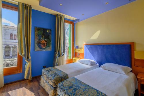 a blue bedroom with two beds and a window at Diamantino Town House in Padova