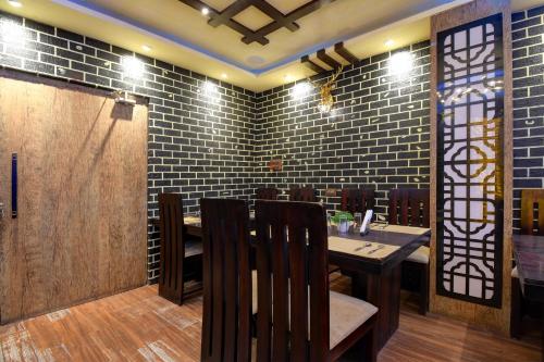 a dining room with a table and chairs and brick walls at Hotel O Chilli Pepper Hotel and Restaurant in Kolkata