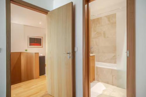 a bathroom with a door open to a bathroom with a tub at Caravela - Torre Sao Rafael in Lisbon
