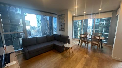 a living room with a couch and a table with chairs at Nest Apartments on Rose Lane in Melbourne