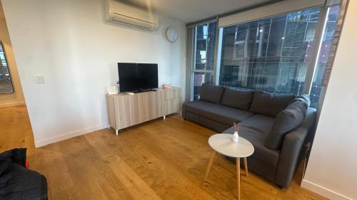 a living room with a couch and a tv at Nest Apartments on Rose Lane in Melbourne